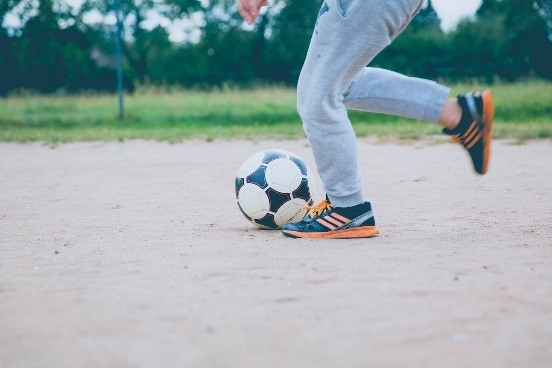 Une personne est sur le point de botter un ballon de soccer.